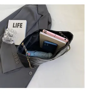 Detail view of the large capacity quilted tote interior with umbrella and phone