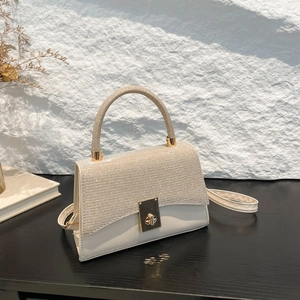 Elegant cream rhinestone handbag with gold twist lock and adjustable shoulder strap