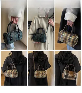 Detail view of vintage plaid Boston bag with leather handles and adjustable shoulder strap