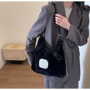 Detail showing plush black bag with white faux fur ears and silver metal chain