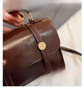 Détail du sac à main vintage en cuir PU marron avec boucle dorée et coutures précises