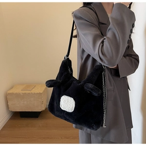 Detail of plush black shoulder bag with fuzzy texture and cute ear design elements