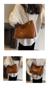 Close-up of brown quilted tote with gold chain strap and glossy PU leather texture
