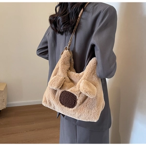 Detail view of large fluffy teddy bear tote bag with puppy face on a female model