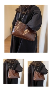 Detail of coffee brown quilted leather tote bag with metal chain strap and luxury finish