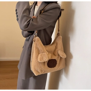 Detail of plush teddy bear tote bag featuring faux fur texture and metal chain strap