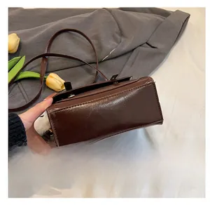 Détail de la base plate d'un sac à bandoulière vintage en cuir PU marron foncé cousu main