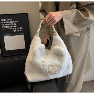Close-up of white plush bag showing fuzzy texture with cute ears and silver chain strap