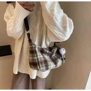Winter plaid crossbody bag detail with white faux fur pompom charm and wide strap