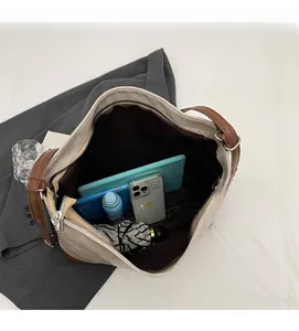 Top view of spacious interior of two-tone tote bag showing various daily essentials