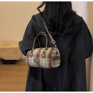 Close-up of vintage plaid wool tote bag with leather handles and adjustable strap