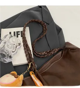 Detail of brown faux leather tote with woven handle and contrast stitching accents