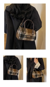 Detail of vintage plaid woolen Boston bag with leather handles and gold-tone hardware
