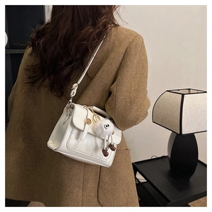 Sac bandoulière blanc en similicuir avec clous décoratifs et breloque peluche blanche