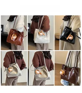 Detail of large tote bags in brown, silver, and black with braided shoulder straps