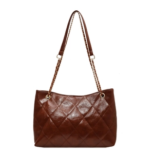 Brown quilted tote bag in glossy faux leather with chain shoulder strap on white background