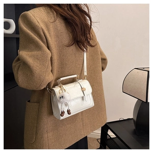 Détail d'un mini sac bandoulière blanc en cuir PU avec poignée métal et peluche