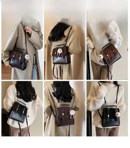 Detail view of vintage leather backpack with plush pendant and metal buckle closure