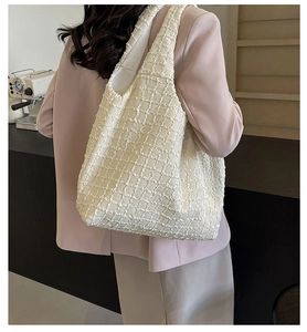 Ivory tote bag with textured relief fabric shown in a stylish cafe commuting scene