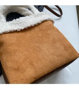 Nahaufnahme von karamellfarbenem Wildleder mit weißem Fleece-Besatz an der Wintertasche
