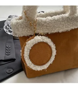 Details der braunen Wildleder-Beuteltasche mit weißem Plüschbesatz und Münztäschchen