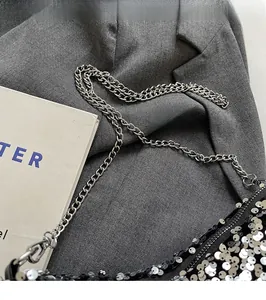 Detail of silver and black sequin shoulder bag with elegant metal chain strap for women
