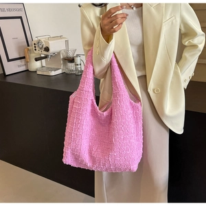 Close-up of pink popcorn fabric texture and wide shoulder strap on the stylish tote bag
