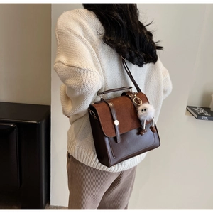 Vue lifestyle d'un sac à dos vintage en cuir bicolore avec pompon sur un mannequin