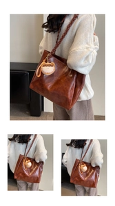 Detail of vintage brown tote bag with thick woven straps and cute cartoon plush charm