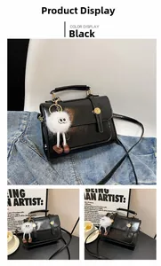 Détail du sac bandoulière en cuir PU noir avec fermoir doré et charm en fourrure blanche