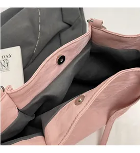 Detailed view of pink tote bag with magnetic clasp and textured pleated material
