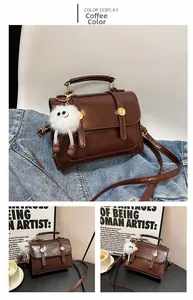 Détail d'un sac bandoulière vintage en cuir PU marron avec pendentif en peluche et métal doré