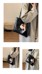 Detail of black PU leather tote bag with woven handles and cute bear charm pendant