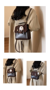 Detail of vintage dark brown backpack with gold hardware and white plush charm