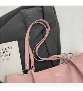 Detail of light pink PU leather tote bag with silver D-rings and comfortable handle strap