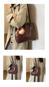 Detail of dark brown tote bag with woven straps and a cute cartoon plush pendant charm