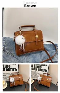 Sac bandoulière vintage marron en similicuir avec boucles dorées et breloque peluche