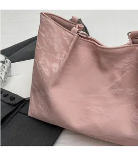 Detail of pink tote bag showing unique wrinkled texture and silver hardware accents