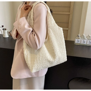 Detail of white tweed tote bag showing thick woven texture and frayed edge trim