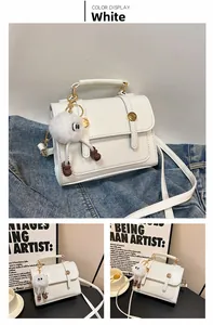 Détail du sac bandoulière blanc en similicuir avec sangles et charme en peluche