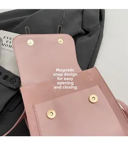 Detail view of the pink leather bag interior featuring dual golden magnetic snap closures