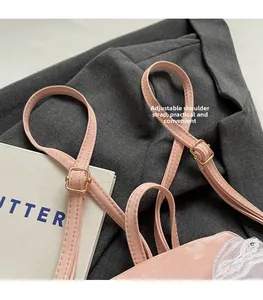 Detail of adjustable pink shoulder strap with gold metal buckle and lace trim