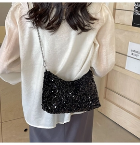 Chic black sequin tote bag with silver chain strap shown on model over white outfit