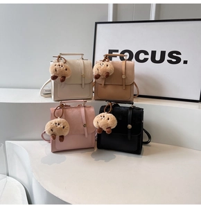 Detail of four colorful mini backpacks with corduroy texture and plush cookie charms
