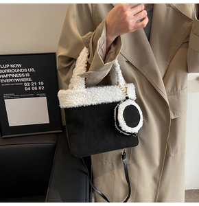 Detail der schwarzen Wildleder-Beuteltasche mit weißem Plüschbesatz und Anhänger