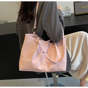 Detailed shot of pink tote bag with pleated texture and silver ring shoulder strap