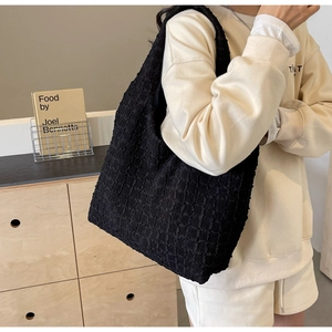 Detail of black pleated bubble fabric tote bag with textured waffle pattern and large capacity