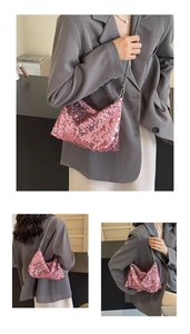 Detail of pink sequin shoulder bag featuring a silver metal chain strap and crescent shape