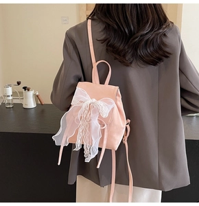 Pink ballet-style backpack featuring a large white lace bow detail and slim straps