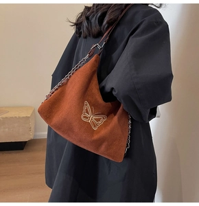 Close-up of golden butterfly embroidery on vintage brown faux suede hobo shoulder bag